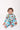 Baby smiling in Sesame Street™ print onesie with blue cuffs